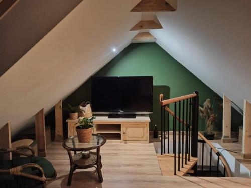 a living room with a flat screen tv in a attic at Słoneczna Sarbinówka in Sarbinowo