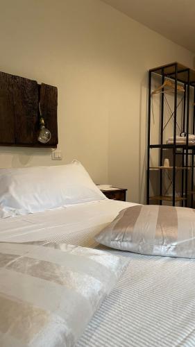 a bedroom with a bed with white sheets and a shelf at Toscana Made in Love in Massa