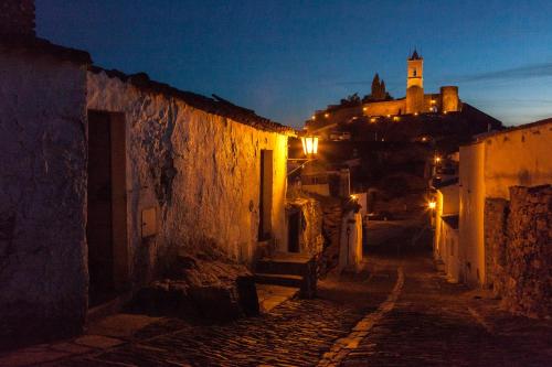 an alley at night with a castle in the background at Monte Farropo in Monsaraz