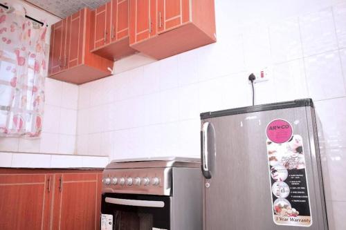 uma cozinha com frigorífico e autocolante em Golden One-bedroom serviced apartment with free WiFi em Kisii