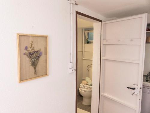 baño con aseo y una pintura en la pared en Appartement entier rénové dans un écrin de verdure, en Thann