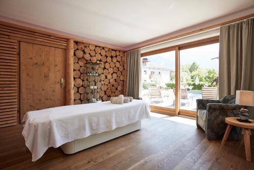 1 dormitorio con cama blanca y ventana grande en Der Brandstetterhof - Adults only, en Stans