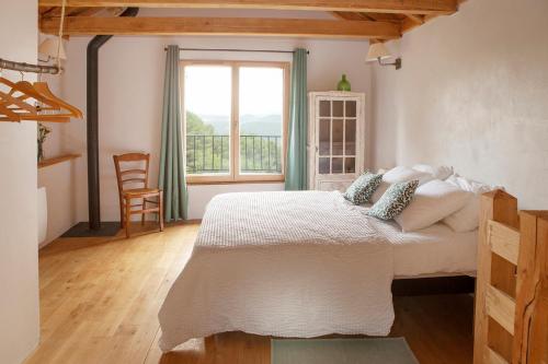 a bedroom with a bed and a large window at L'aube des Fourniels in Malbosc