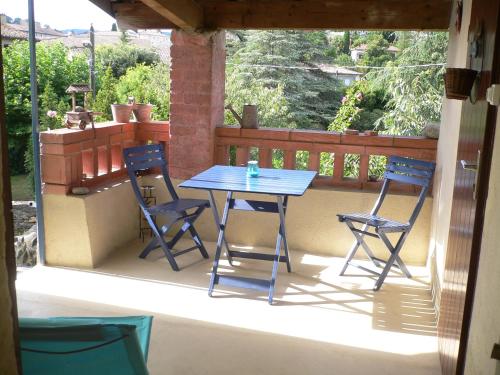 une table bleue et deux chaises sur un balcon dans l'établissement Maison de village Ardéchoise à Les Vans, aux Vans