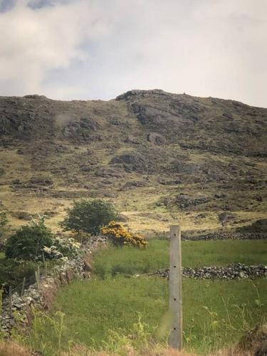 a fence in a field with a hill in the background at Mountain House Omeath near Carlingford in Ó Méith