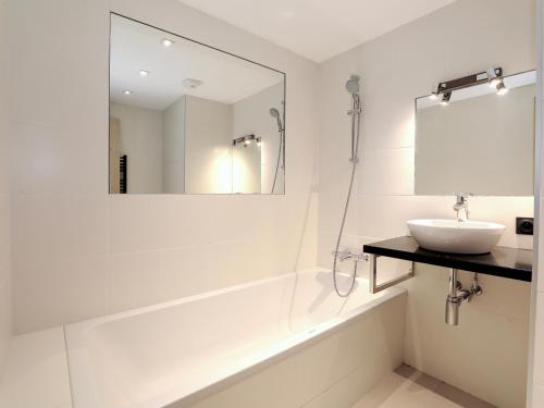 a white bathroom with a sink and a mirror at Magnifique duplex 3 chambres à Courchevel avec balcon, parking, et WIFI - FR-1-575-107 in Courchevel
