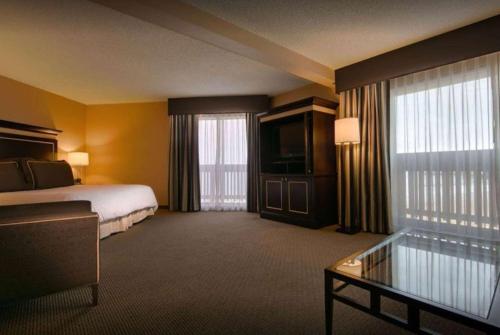 una camera d'albergo con letto e TV di Pacifica Lighthouse Hotel Trademark Collection by Wyndham a Pacifica