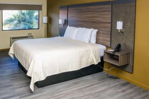 um quarto de hotel com uma cama grande e um telefone em Rodeway Inn em Phenix City
