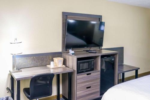凤凰城Rodeway Inn Phenix City - Columbus的酒店客房设有电视和带椅子的书桌