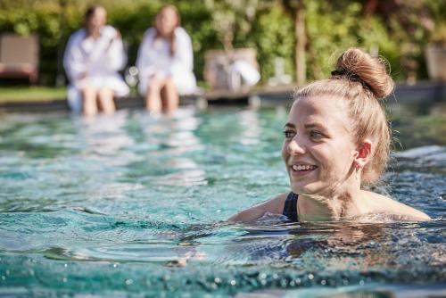 una joven en una piscina en Der Brandstetterhof - Adults only, en Stans