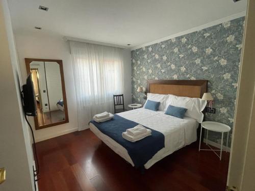 um quarto com uma cama com papel de parede azul e branco em La Terraza de los Infantes em Zamora