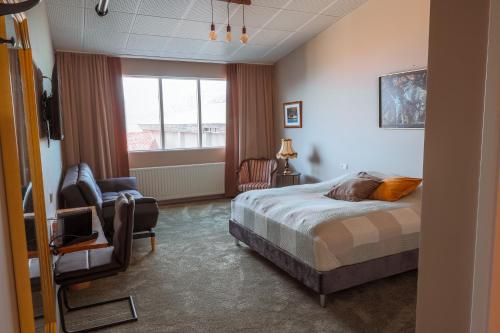 Litli-ÁrskógssandurにあるHotel Kaldiのベッドルーム1室(ベッド1台、椅子、窓付)