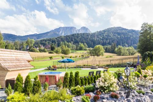 un jardín con vistas a la montaña en udanypobyt Domki Przy Potoku en Zakopane