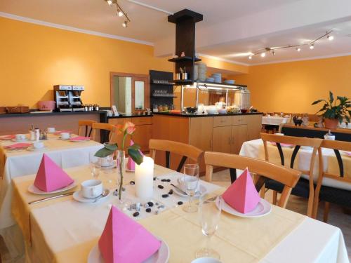 un ristorante con due tavoli con cappelli rosa per feste di Zentral Hotel a Bad Füssing