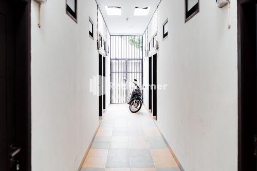 TanjungkarangにあるAksara Homestay Syariah Mitra RedDoorzの廊下中に停まったスクーター
