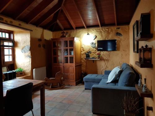 a living room with a blue couch and a table at Finca Los Ciruelos Casas Rurales in Icod de los Vinos