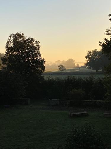 a view of a field with trees and the sunset at Urlaub im Wasserschloss Irmelshausen in Höchheim
