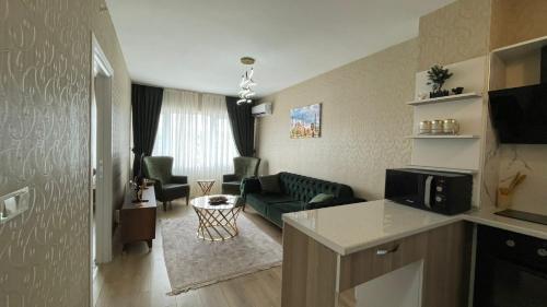 ein Wohnzimmer mit einer grünen Couch und einem Wohnzimmer in der Unterkunft Luxe Suite AI3 in Esenyurt