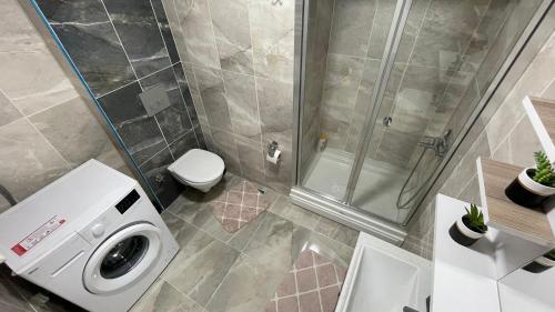 ein Badezimmer mit Waschmaschine und Dusche in der Unterkunft Luxe Suite AI3 in Esenyurt