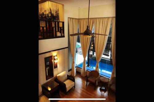 sala de estar con sofá y ventana grande en LF Tropical Pool Villa, en Johor Bahru