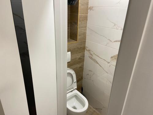 ein Badezimmer mit einem weißen WC in einer Kabine in der Unterkunft Sweethome Riscani in Chişinău