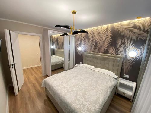 ein Schlafzimmer mit einem Bett und einer Wand mit einem Wandbild in der Unterkunft Sweethome Riscani in Chişinău