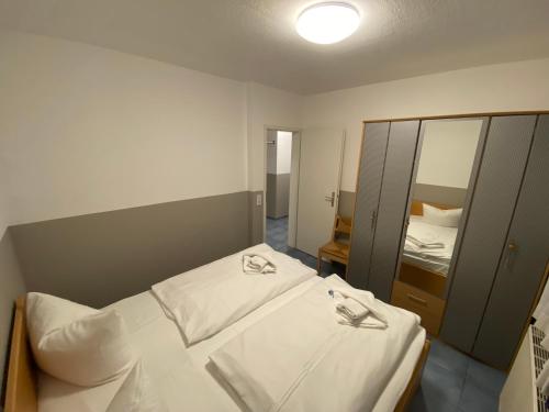 Habitación pequeña con 2 camas y espejo. en "Am Yachthafen" en Seedorf