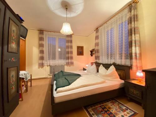 a bedroom with a bed in a room with windows at Gasthof-Pension Hochsteiner in Glödnitz