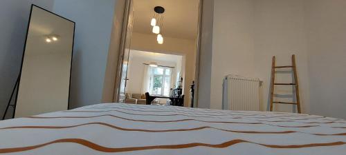 a bedroom with a large bed and a mirror at Entre 2 Ourthes in La Roche-en-Ardenne