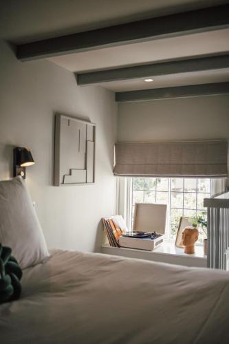 a bedroom with a bed and a window with a laptop at FINCH Boutique Hotel, downtown in Deventer
