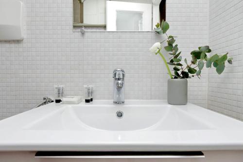a bathroom sink with a vase with a plant on it at Campo de Fiori in Rome