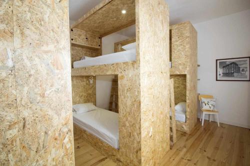 two bunk beds in a room with a stone wall at Patinha Inn in Évora