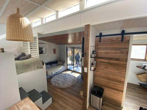 a room with a bed and a sliding glass door at ReThynk Unique Tiny home East Jindabyne in Jindabyne