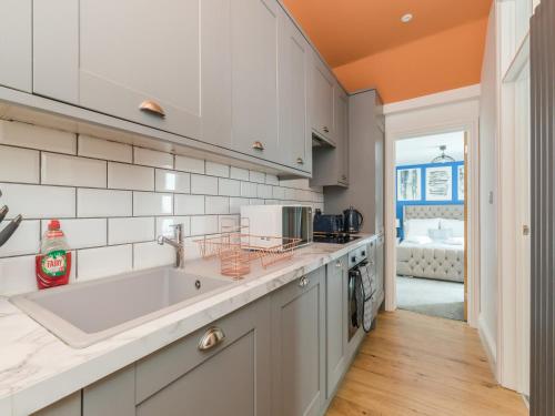 a kitchen with a sink and a counter at Stylish 2-bedroom flat with patio and garden in Brighton & Hove