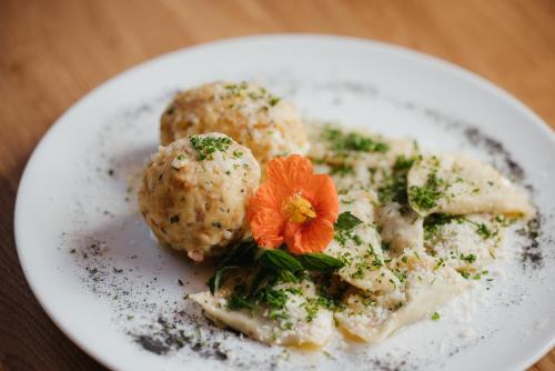 a plate of food with meatballs and a flower on it at Plattnerhof Viums in Natz-Schabs