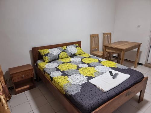 Una cama con una colcha encima en una habitación. en CHAMBRES PRIVEES CLIMATISEE ACCES DOUCHE -CUISINE-SALON, en Dakar