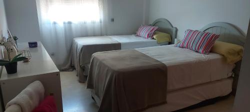 a small room with two beds and a window at Apartment in Benalmádena - Luxury Complex Bellagio in Benalmádena