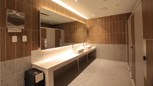 La salle de bains est pourvue de 2 lavabos et d'un grand miroir. dans l'établissement Mini Hotel 141, à Gyeongju