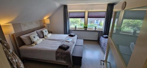 een slaapkamer met een bed en 2 ramen bij Bed & Breakfast Ravelin in Rees