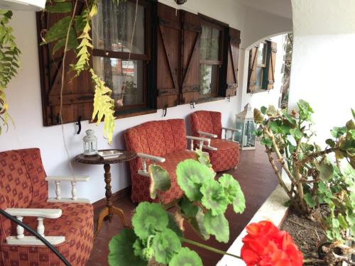 un porche con 2 sillas, una mesa y algunas plantas en La Casita de Las Palmas VV, en Las Palmas de Gran Canaria