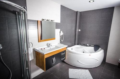 a bathroom with a tub and a sink and a toilet at Hotel El Bey in Constantine