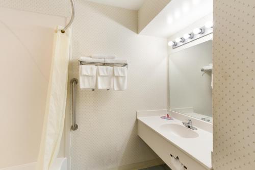 a white bathroom with a sink and a mirror at Malone Inn in Malone