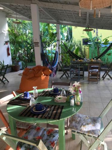 a green table and chairs in a living room at Pousada Tangerina in Icaraí