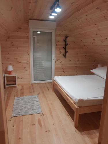 a bedroom with a bed in a log cabin at Osada Szwedzka Domek Plus in Rusinowo