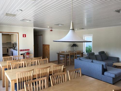 a living room with a blue couch and a table and chairs at Halens Camping och Stugby in Olofström