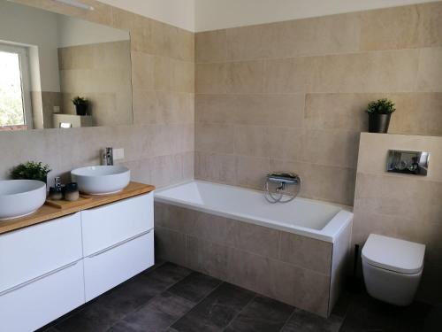 a bathroom with a tub and a toilet and a sink at Townhouse Altstadt Wismar Upper Apartment mit zwei Terrassen in Wismar
