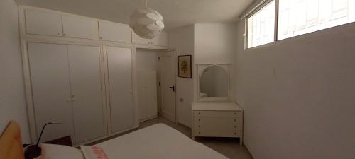 ein weißes Schlafzimmer mit einem Waschbecken und einem Spiegel in der Unterkunft APARTAMENTO EN EL MEDANO - ESTRELLA DEL MAR in Granadilla de Abona