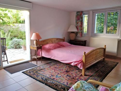 1 dormitorio con cama con sábanas rosas y ventana en T1 ou T2 dans villa avec jardin proche Biarritz, en Anglet