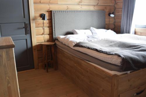 a bed with a wooden headboard in a room at Trysilsetra 35 in Trysil