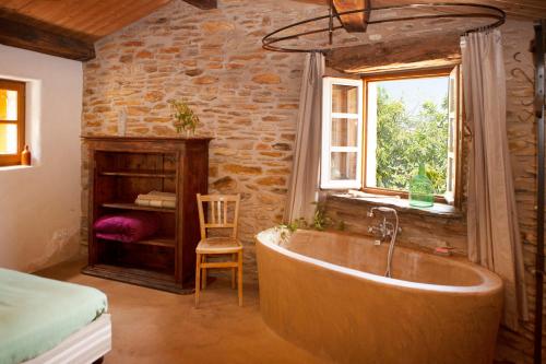 a bathroom with a tub in a room with a window at L'aube des Fourniels in Malbosc